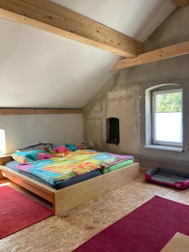 a bedroom with a bed with colorful blankets and rugs at Ölschnitzer Loft in Lampertswalde