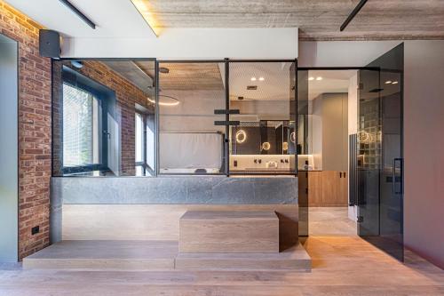 カウナスにあるDesign 2 BD Apartment with Hot Tube by Domviaのベンチ付きのガラス壁シャワー付きのバスルーム