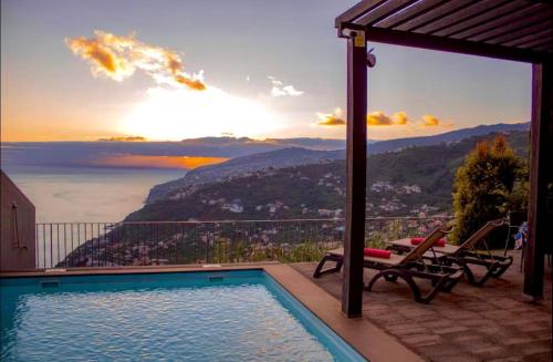 a swimming pool with a view of the mountains at Sunset Dreams - Arco da Calheta in Arco da Calheta