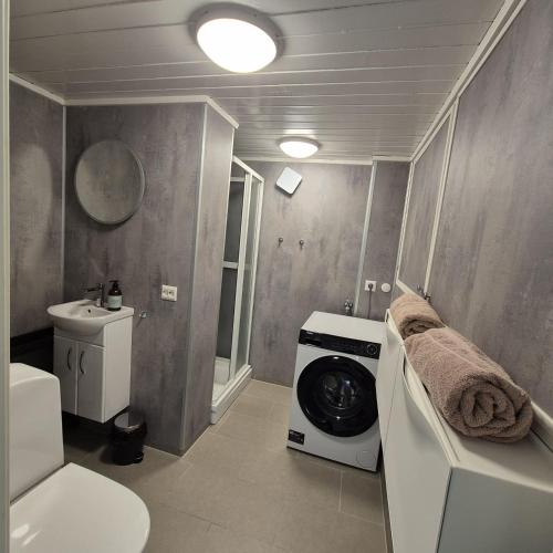 a washing machine in a bathroom with a washer at Just Sleep Arendal in Arendal