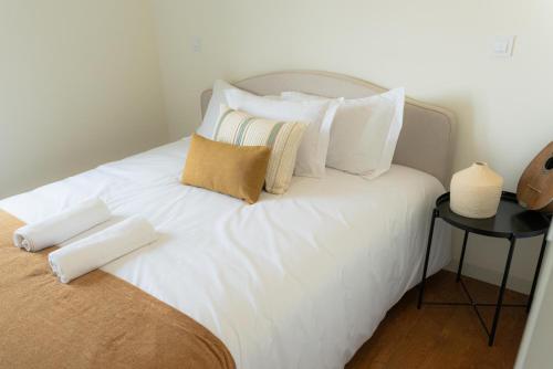 a white bed with white pillows on top of it at Casa Pitoresca - Refugio Esposende in Gemeses