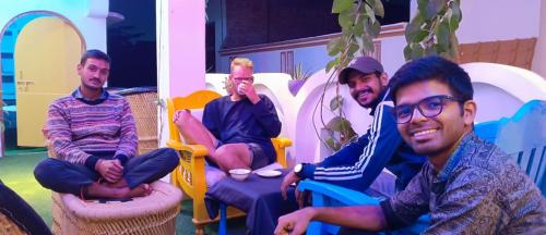 a group of four men sitting in chairs at Manavi Home Stay in Mathura