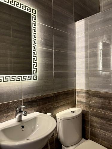 a bathroom with a sink and a toilet and a mirror at Exquisite & inviting 2 Bedroom 2 bath Balcony Fast internet in Amman