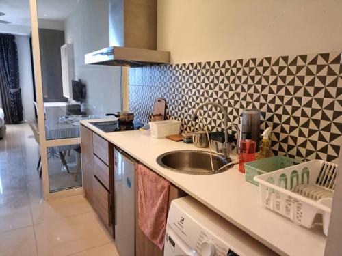 eine Küche mit Spüle und geometrischer Wand in der Unterkunft Sk Tower in Dhaka