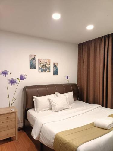 ein Schlafzimmer mit einem großen Bett und weißen Kissen in der Unterkunft Sk Tower in Dhaka