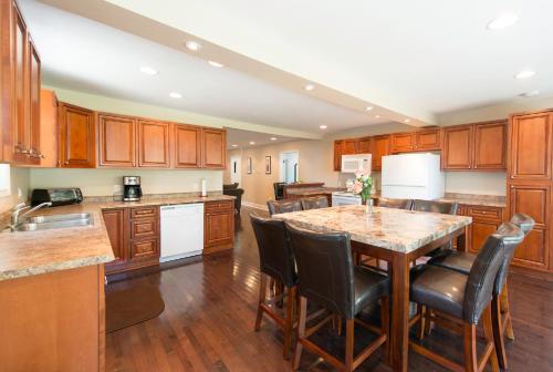 Una cocina con gabinetes de madera y una mesa con sillas. en Walk To The Beach, en Fort Erie