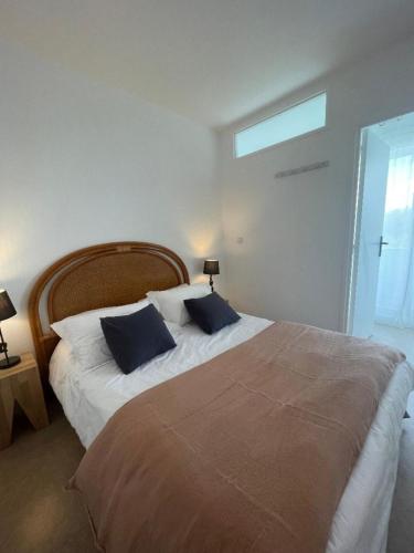 une chambre avec un grand lit et deux oreillers bleus dans l'établissement Côté Thalasso, à Quiberon