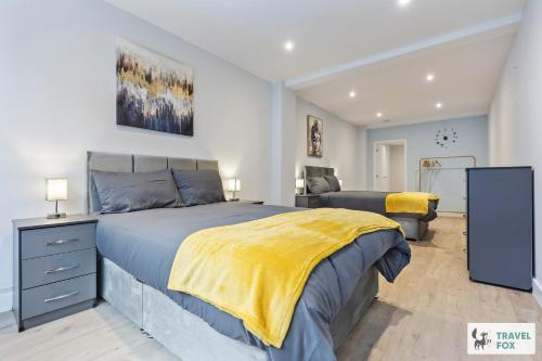 a bedroom with a large bed with a yellow blanket at Blair's Central Stay in Nottingham
