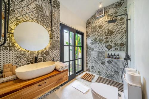 a bathroom with a tub and a mirror on the wall at Balance, Beauty and WiFi - Find It All at Sarang Apartments 2 in Ubud