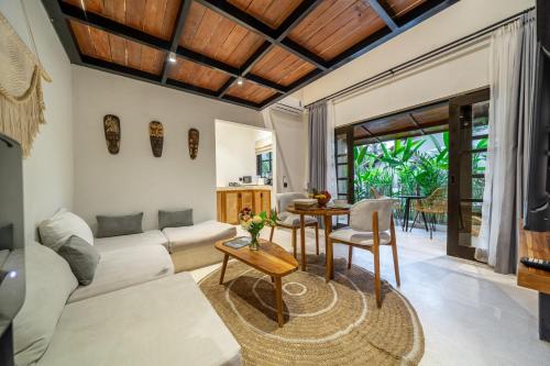 a living room with a couch and a table at Balance, Beauty and WiFi - Find It All at Sarang Apartments 2 in Ubud
