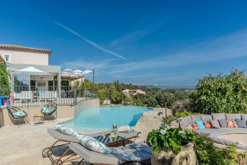 Una piscina con sillas y una mesa al lado de una casa. en Villa With Pool In The Heart Of French Riviera, en Valbonne