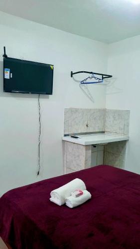 a bedroom with a bed with two towels on it at suíte feliz in Belém