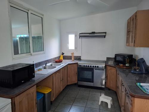 eine Küche mit Spüle und Herd in der Unterkunft Ti Kaz Fifine, bord de mer in Sainte-Anne