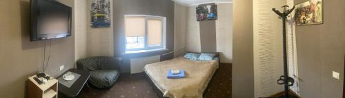 a small room with a bed and a tv at Міні готель & хостел Шервуд in Zhytomyr