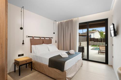 a bedroom with a bed and a view of a patio at Luxury Suites with private pool and BBQ by Kalles Homes & Suites in Áno Kalésia
