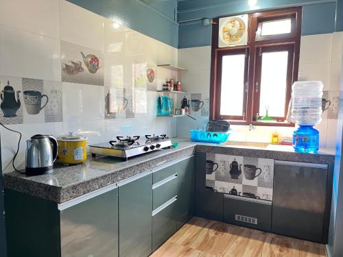 a kitchen with a stove and a counter top at RJ Shant Apartments- Flat 22 in Hāpoli