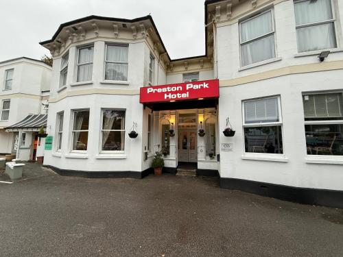 a white building with a red sign on it at Preston Park Hotel in Brighton & Hove