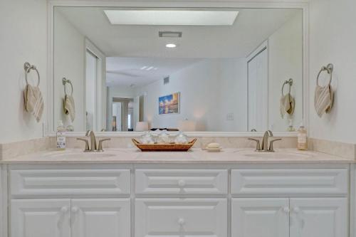 een badkamer met twee wastafels en een grote spiegel bij Beachfront Luxury with Spectacular Ocean Views! in Ormond Beach