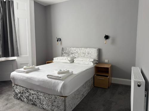 a bedroom with a bed with two towels on it at Preston Park Hotel in Brighton & Hove