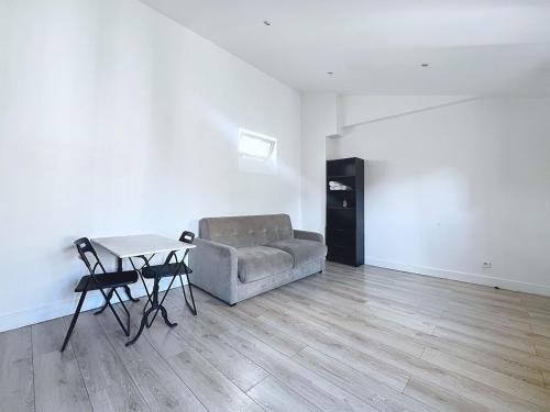 a living room with a couch and a table at Cocon lumineux à la porte de Paris in Gentilly