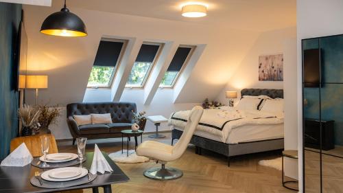 a bedroom with a bed and a chair and a table at Bliss & Relax Central Apartment Debrecen, Free Parking in Debrecen