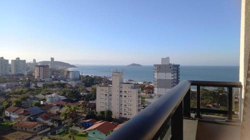 Una vista de una ciudad con el océano y edificios. en Apto com piscina a 150m da Praia!, en Penha