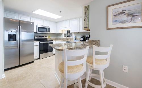 a kitchen with stainless steel appliances and white cabinets at Phoenix East 203 condo in Orange Beach