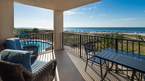 a balcony with a table and chairs and the beach at Phoenix East 203 condo in Orange Beach