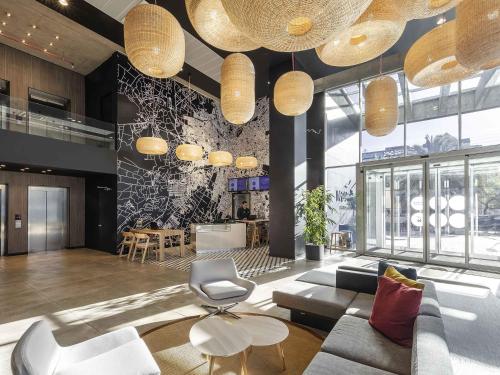 a lobby with a couch and a table and chairs at Novotel Santiago Providencia in Santiago