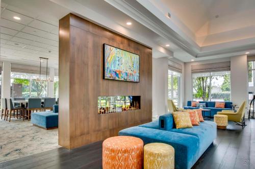 a lobby with a blue couch and a fireplace at Hilton Garden Inn Louisville Airport in Louisville