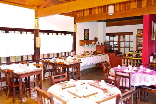 a dining room with tables and chairs in a restaurant at Pousada Sotaque Mineiro in Cunha