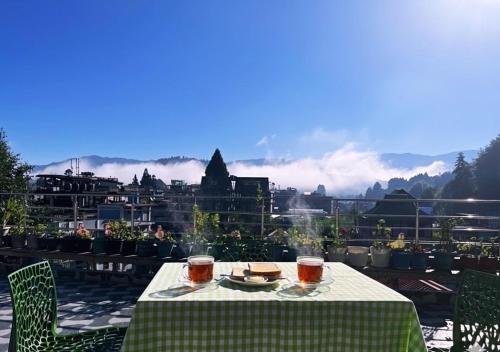 a table with a plate of food and drinks on a balcony at Flat 9-RJ Shant Apartment &Homestay in Hāpoli