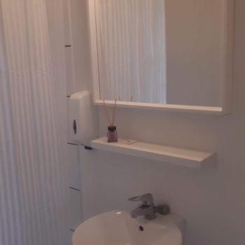 a white bathroom with a sink and a mirror at Motel Egense in Storvorde