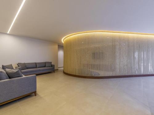a living room with a couch and a large wall at Novotel Salvador Rio Vermelho in Salvador