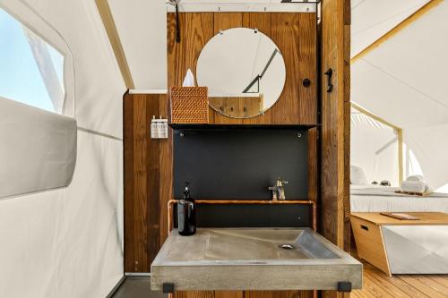 a bathroom with a sink and a mirror at Under Canvas White Mountains in Dalton