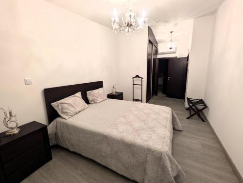 a bedroom with a large bed and a chandelier at Casa do Margalho in Miranda do Douro