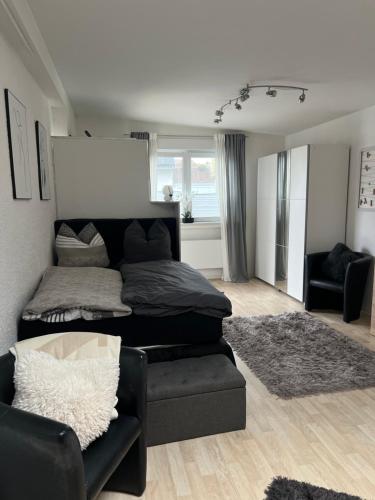 a bedroom with a bed and a couch and a chair at Gemütliches, barrierefreies Apartment in Dortmund-Brackel, Ruhige Lage, nur 5 Minuten zum Flughafen Dortmund in Dortmund