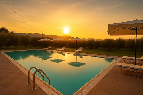 a swimming pool with a sunset in the background at villa Diamante in Lamporecchio