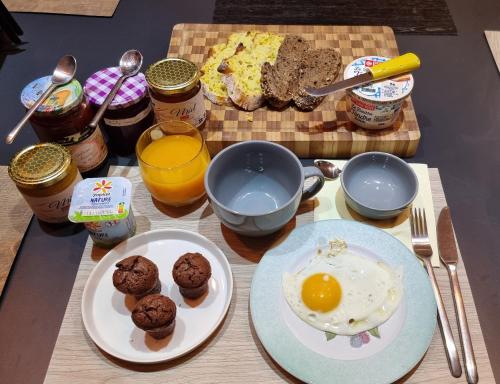 Una mesa cubierta con platos de huevos y muffins en Gerlande, en Bourg-Argental