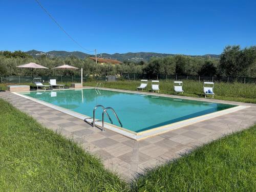 a swimming pool in a field with chairs around it at villa Diamante in Lamporecchio