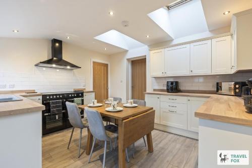 a kitchen with a wooden table and chairs at Pear Tree Cottage Pool Table 15mins drive to Alton Towers in Denstone