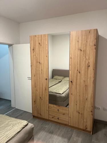 a wooden cabinet with a bed inside of it at Apartman UNO in Batajnica