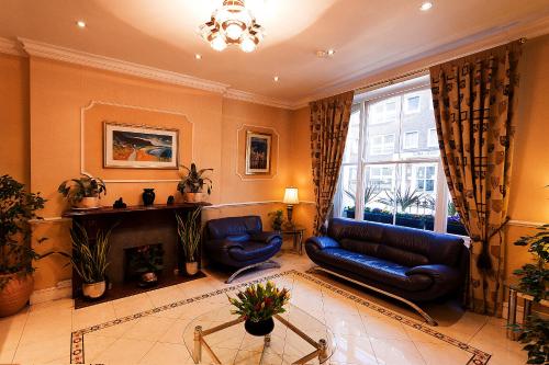 sala de estar con sofá y chimenea en Avon Hotel, en Londres