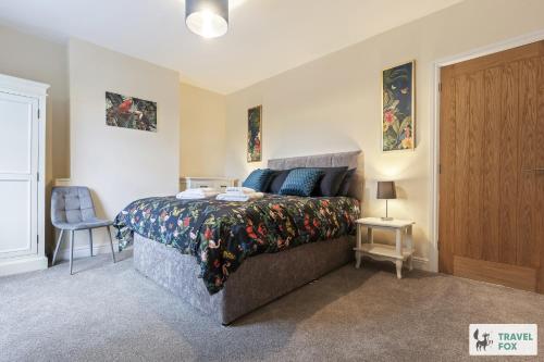 Un dormitorio con una cama y una silla y una puerta. en Pear Tree Cottage Pool Table 15mins drive to Alton Towers, en Denstone