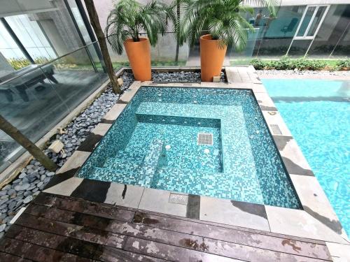 a swimming pool with blue tiles in a house at Couple Studio Cozy Room Klcc BY AA GLoBAL in Kuala Lumpur