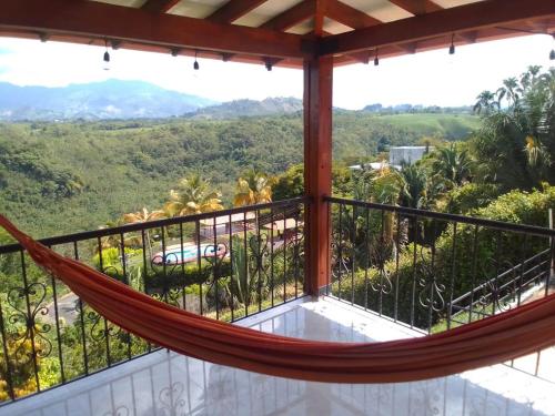 een hangmat op het balkon van een huis met uitzicht bij Finca Hotel Gudys in Estación Belmonte