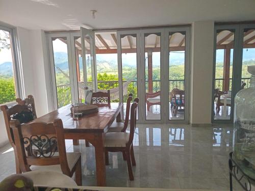 een eetkamer met een tafel en stoelen en een balkon bij Finca Hotel Gudys in Estación Belmonte