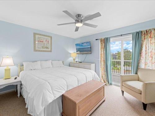 a bedroom with a bed and a chair and a window at Seabreeze village 5 in Dewey Beach