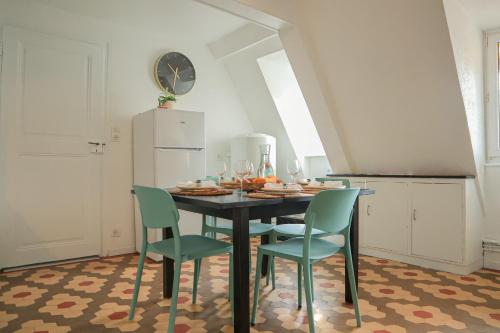 a kitchen with a table with chairs and a refrigerator at Charme et confort au coeur de Mulhouse - Dolce Vita in Mulhouse