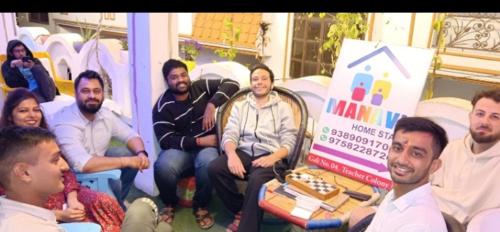 a group of people sitting around a table with a cake at Manavi Home Stay in Mathura